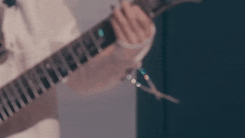 a close up of a person playing a guitar with a pair of scissors in the background .