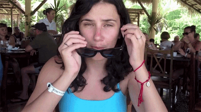 a woman wearing sunglasses has a wristband that says ' abercrombie and fitch ' on it