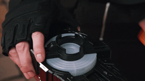 a person wearing black gloves is holding a screwdriver in their hand