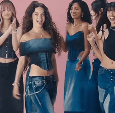 a group of women standing next to each other with one wearing a corset top