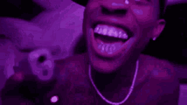a man is holding a gun in a car with purple lights .