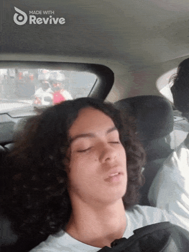 a young man sleeping in the back seat of a car with the words made with revive on the bottom