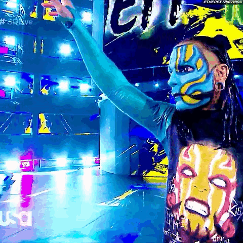 a man with blue and yellow face paint is wearing a shirt with a face on it