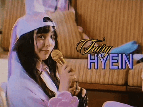 a girl holding a microphone with the name fairy hyein on the bottom right