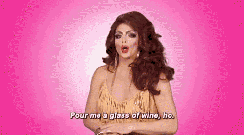 a drag queen is holding a glass of wine and saying `` pour me a glass of wine , ho '' .