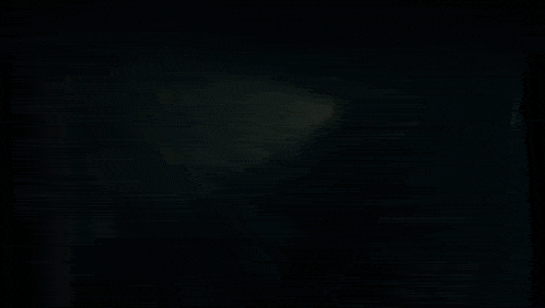 a person is standing in a dark cave with a light coming out of the top