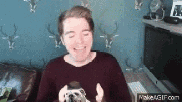 a man is smiling while holding a dog in his hands .