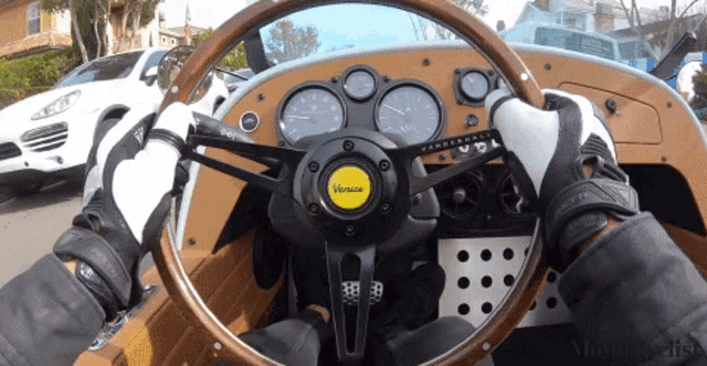 a person is driving a car with a steering wheel that says vanson