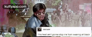 a man wearing sunglasses is screaming in front of a crowd of people .