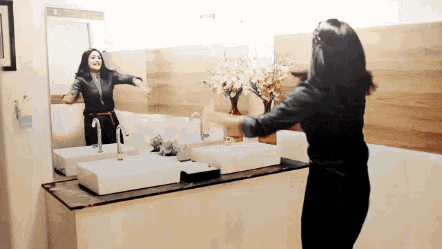 a woman is standing in front of a bathroom mirror dancing