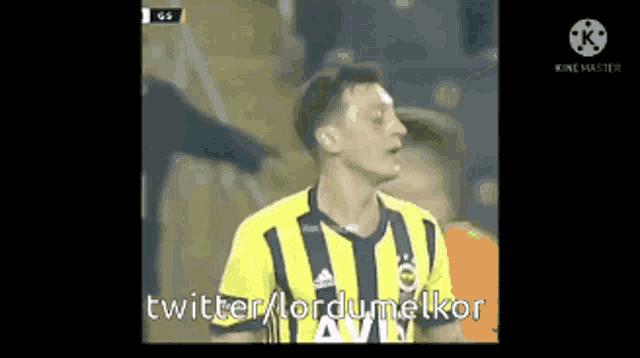 a soccer player wearing a yellow and blue striped jersey is talking to someone on a screen .