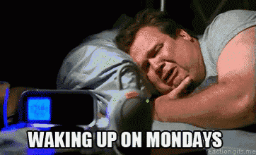 a man is laying in bed with the words waking up on mondays