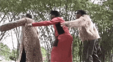 a group of people are standing next to each other in a forest .