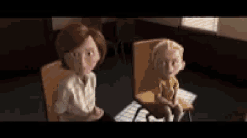a woman and a boy sit in chairs in a room