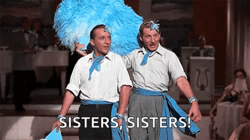 two men are standing next to each other on a stage and they are wearing blue feathers .