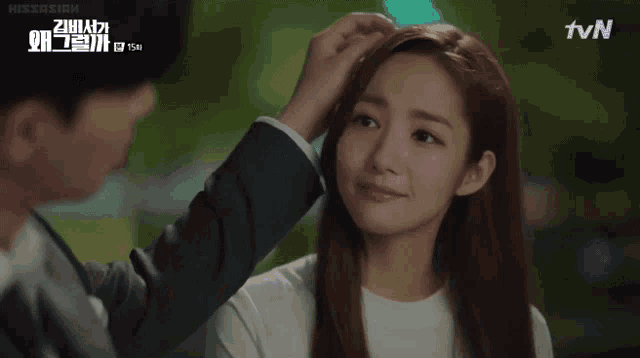 a man is touching a woman 's forehead with the tvn logo behind him