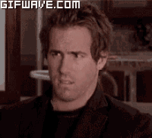 a close up of a man 's face with a gifwave.com watermark on the bottom .