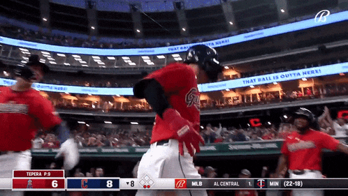 a baseball game is being played in a stadium with a scoreboard that says " that ball is outta here "