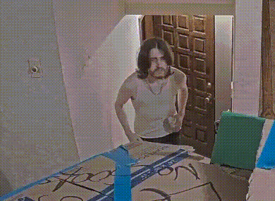 a woman is standing in front of a mirror and looking at herself in a room .