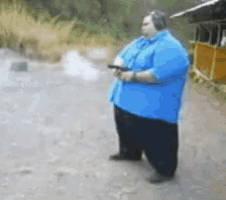 a man in a blue shirt and black pants is holding a gun