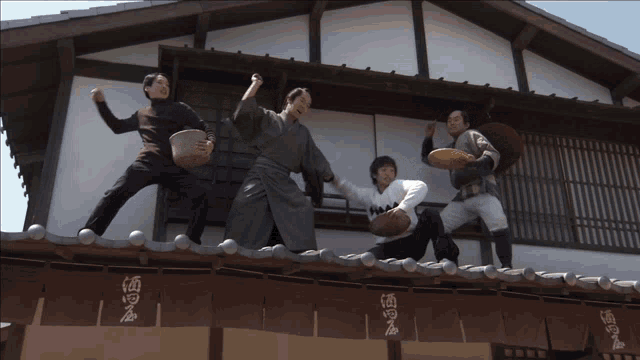 a group of people standing on top of a building with chinese writing