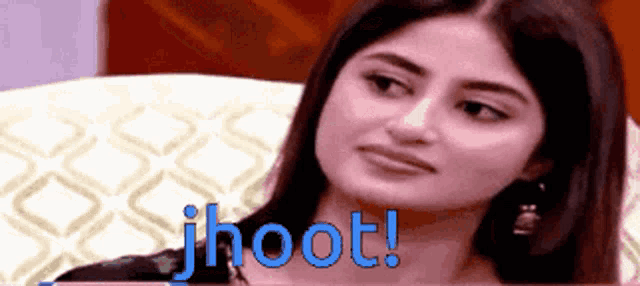 a woman is sitting on a couch with the word jhoot written on the bottom of her face