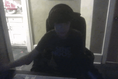 a person wearing a shirt that says " sense proof " sits at a desk