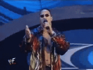 a man singing into a microphone with the word wwe on the bottom