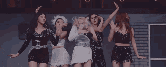 a woman in a white dress is surrounded by other women in black dresses