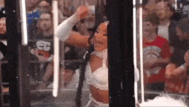 a woman is dancing in front of a crowd of people .