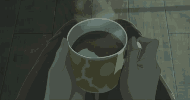 a person is holding a cup of coffee that is steaming