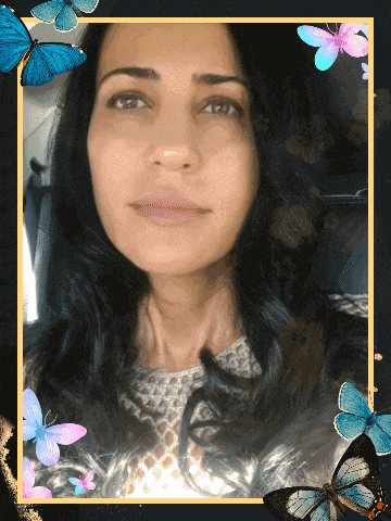 a woman 's face is surrounded by blue butterflies on a black background