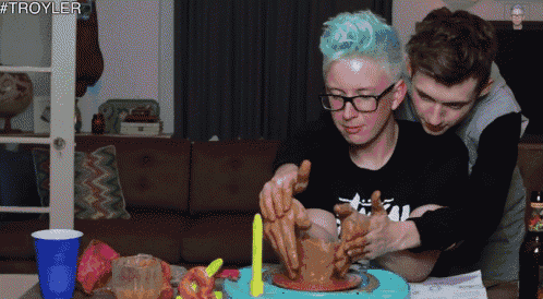 a man with green hair is making a clay pot