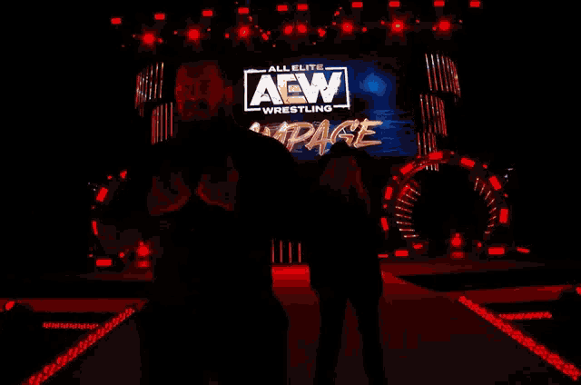 two people are standing in front of a large screen that says all elite aew wrestling rampage