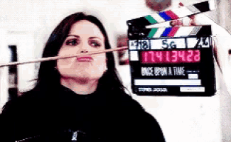 a woman is making a funny face in front of a clapper board that says once upon a time on it