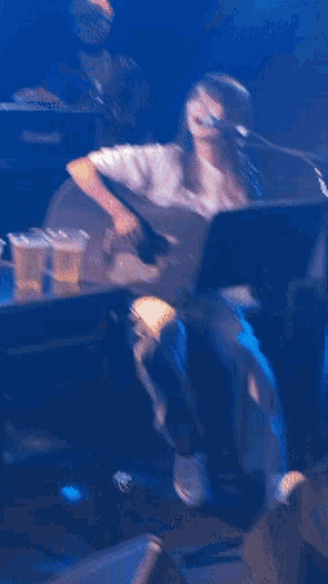 a woman is singing into a microphone in front of a marshall amplifier