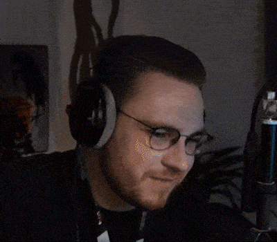 a man wearing glasses is sitting in front of a microphone