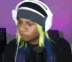 a person wearing headphones and a beanie with yellow hair .