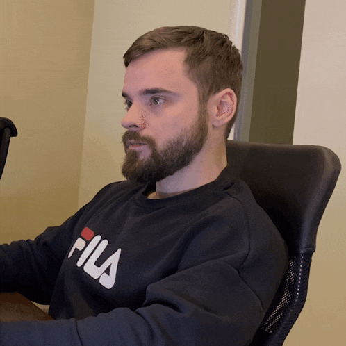 a man with a beard wearing a fila sweatshirt