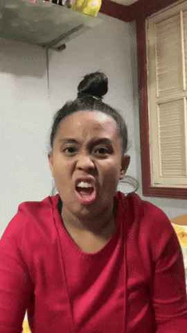 a woman in a red shirt makes a funny face