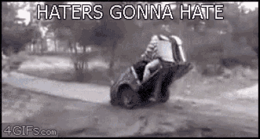 a car is driving down a road with the words `` haters gonna hate '' written above it .
