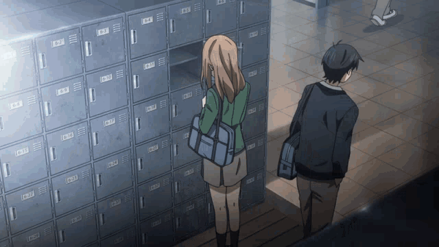 a man and a woman are standing in front of a row of lockers with the letters a and b on them