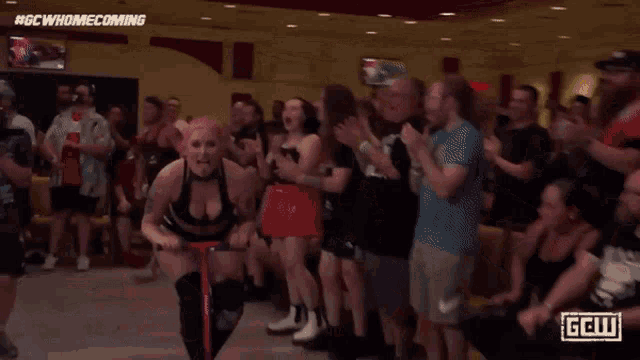 a woman with pink hair and tattoos is wearing a black bra