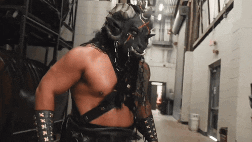 a man in a mask with horns is standing in a building