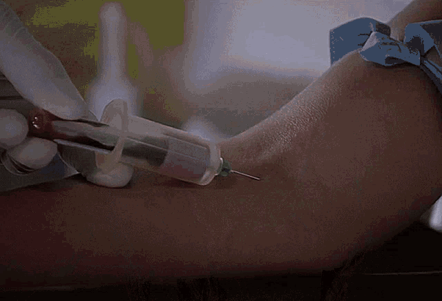 a person is getting blood taken from their arm