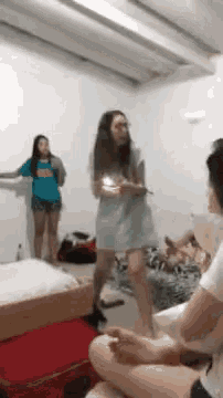 a woman in a blue dress is dancing in a room with other people