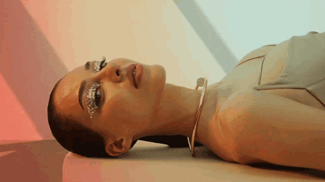 a woman with glitter on her face is laying down on a bed