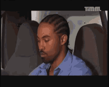 a man is sitting in the back seat of a car .