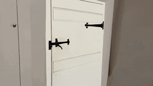 a close up of a white door with black hinges and a butterfly on it .