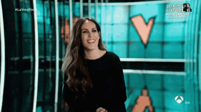 a woman is smiling in front of a screen that says lavozfine